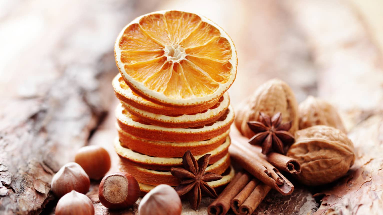 Nuts, spices and orange slices on wood.