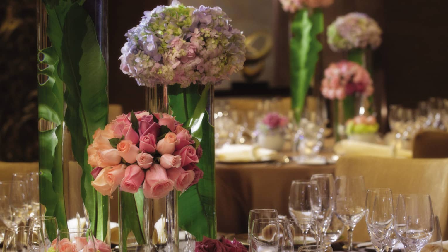 Pink roses in glass vase on formal dining banquet table