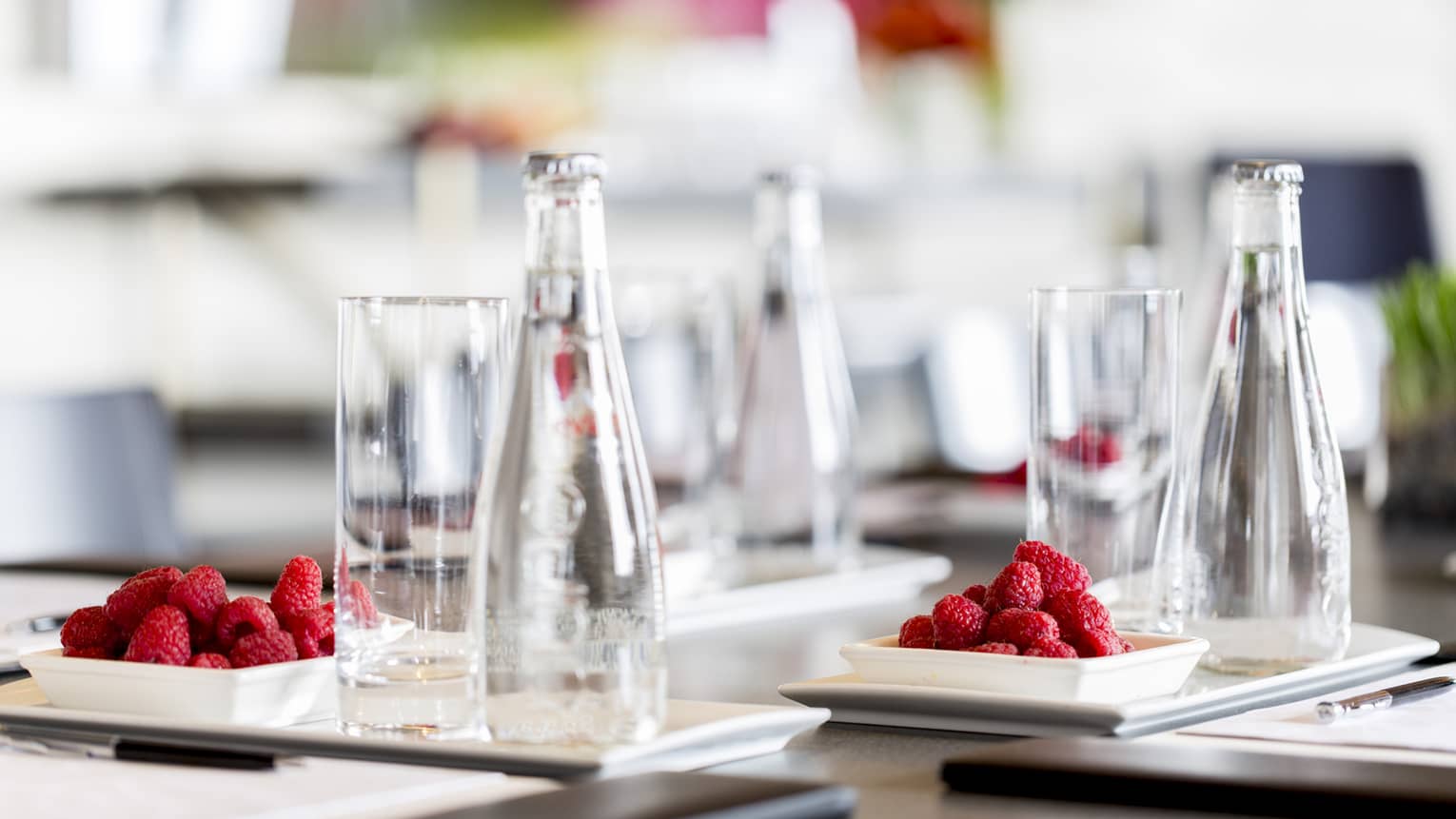 A detail from a meeting – clear glasses and red raspberries on a dark wooden table at Four Seasons Atlanta