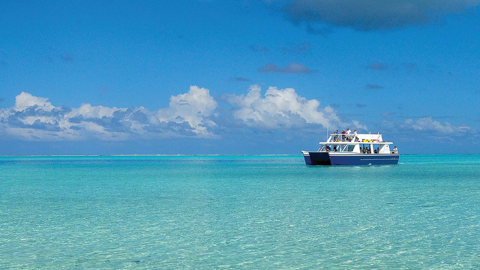 Guests on Four Seasons catamaran boat on lagoon