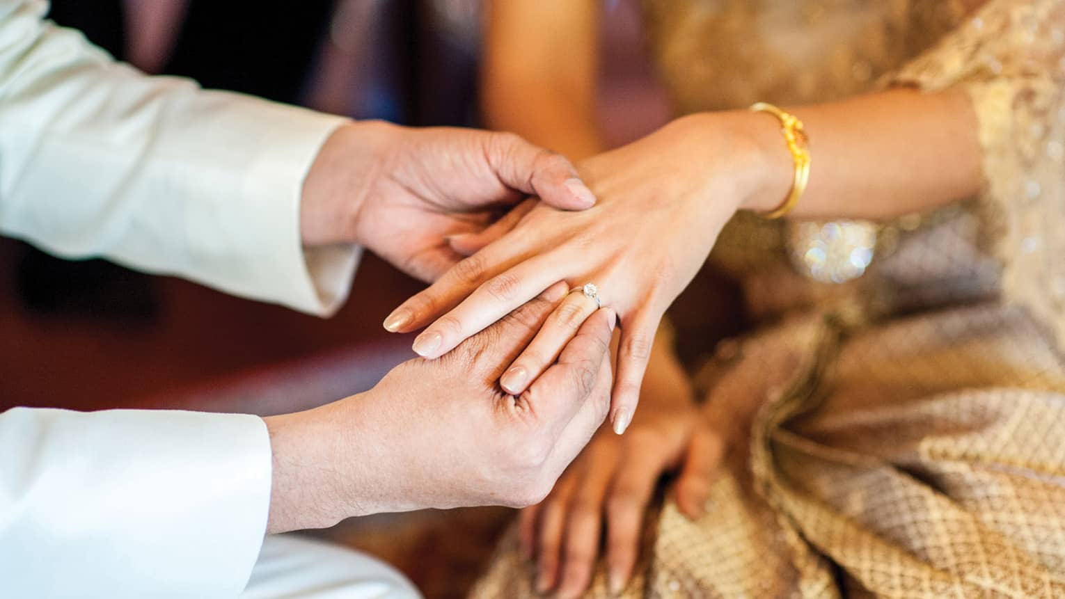 Groom slips wedding ring onto bride's finger 