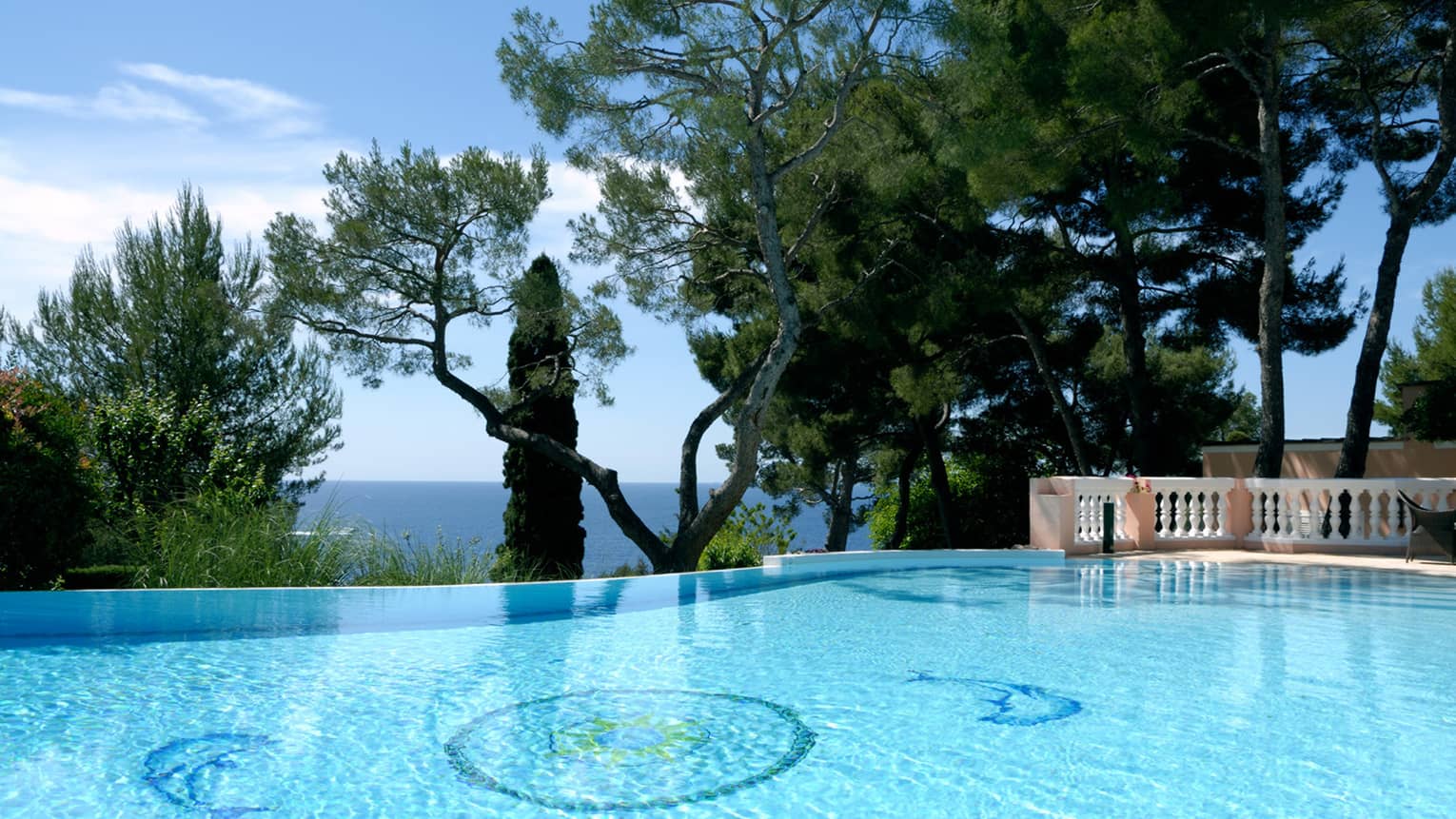 Blue outdoor swimming pool, trees, sea views