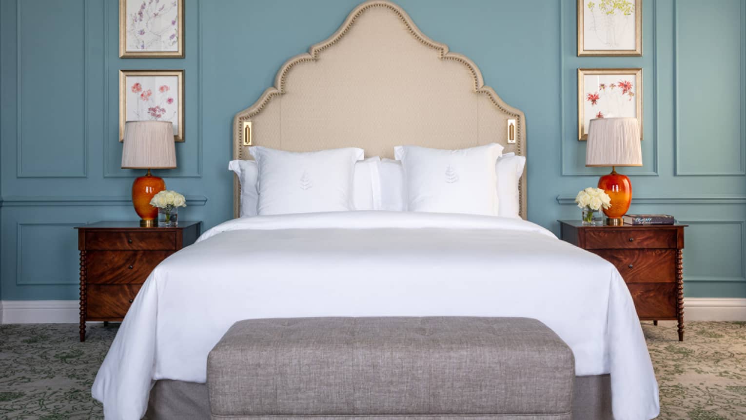 Guest room with Queen bed, white linens, cream headboard, paisley carpeting, cherry bed side tables, turquoise walls
