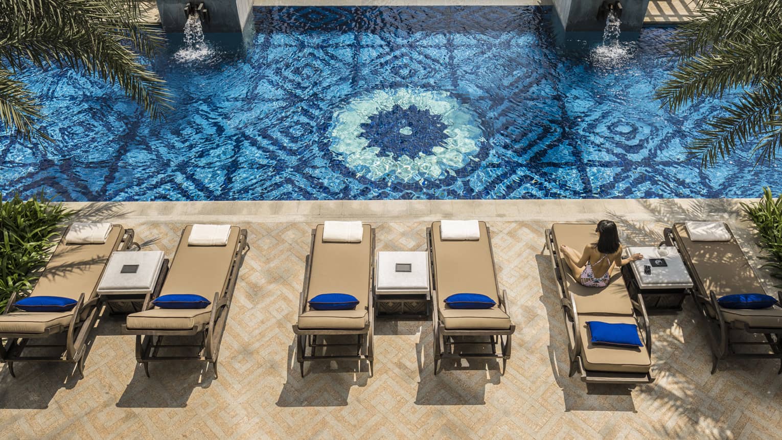 Aerial view of two patio lounge chairs and outdoor swimming pool deck