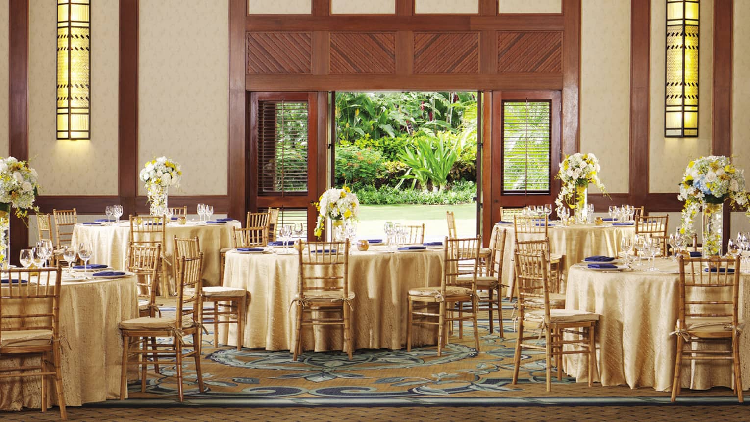 Hualalai ballroom with round banquet dining tables under high ceilings, open door to garden