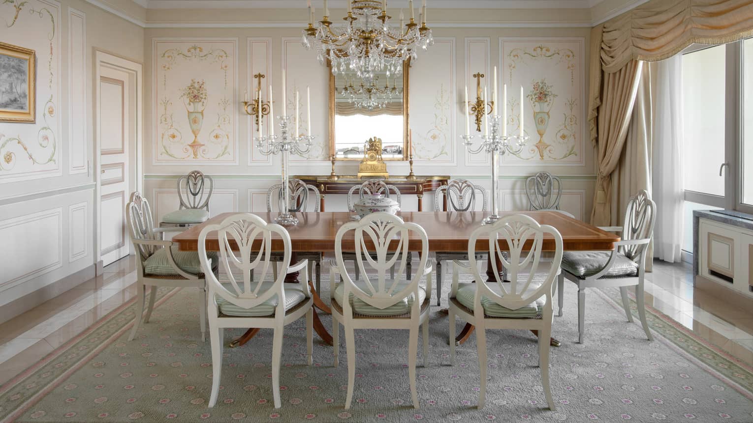 Presidential Suite formal dining room with chandelier over rectangular wooden table and white chairs