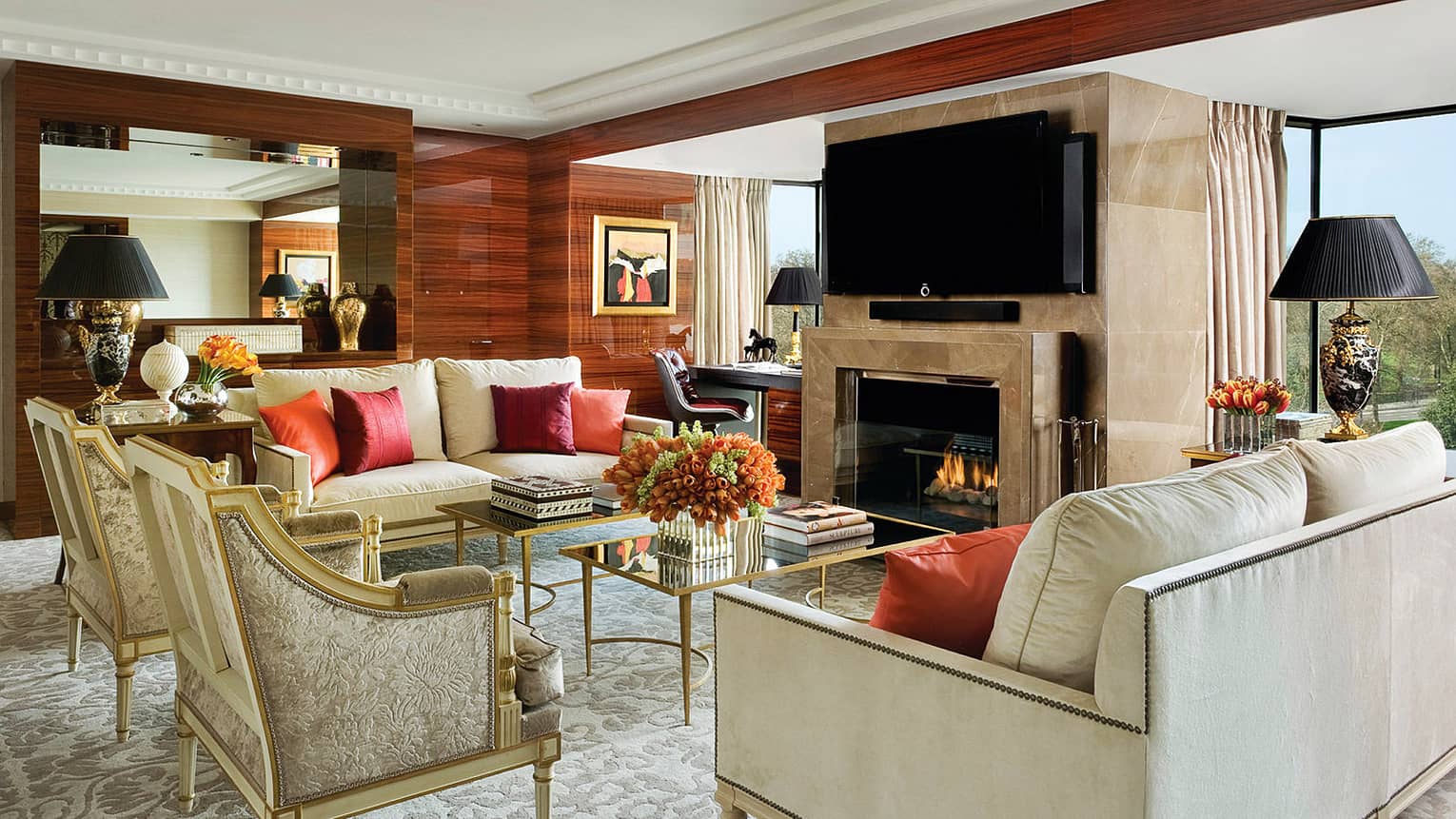 Presidential Suite London, displaying elegant white sofas, armchairs by marble fireplace, desk, windows