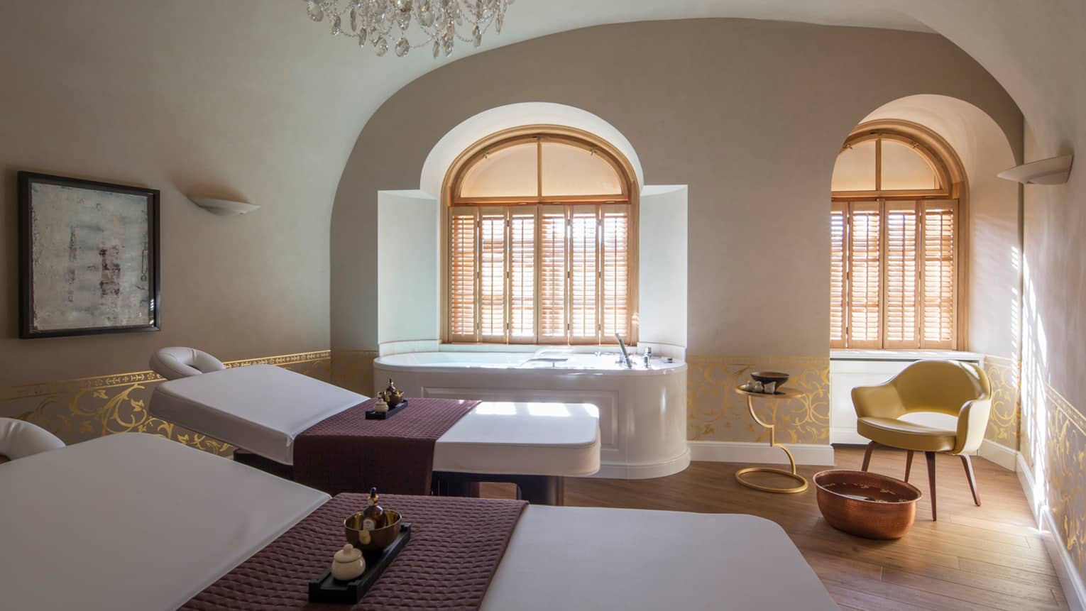Two white beds beside spa tub in dimly-lit room at the Vltava Suite at AVA Spa