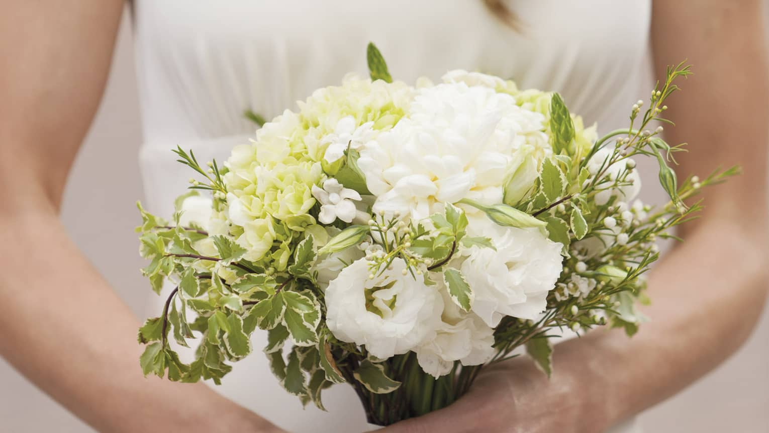 Bride holding white floral wedding bouquet 