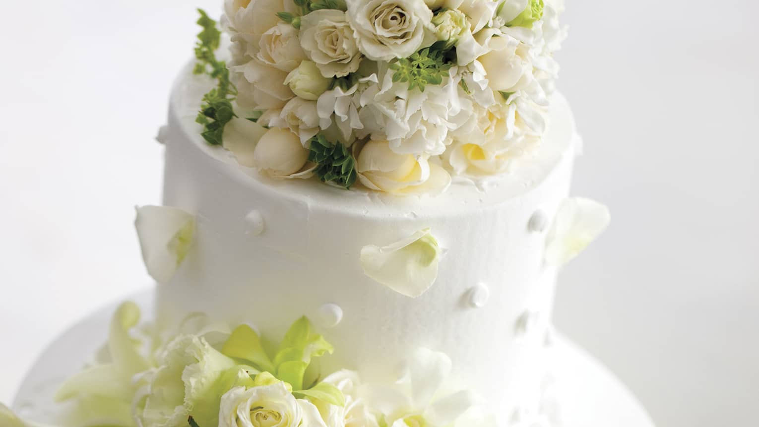 Tiered wedding cake decorated with white roses