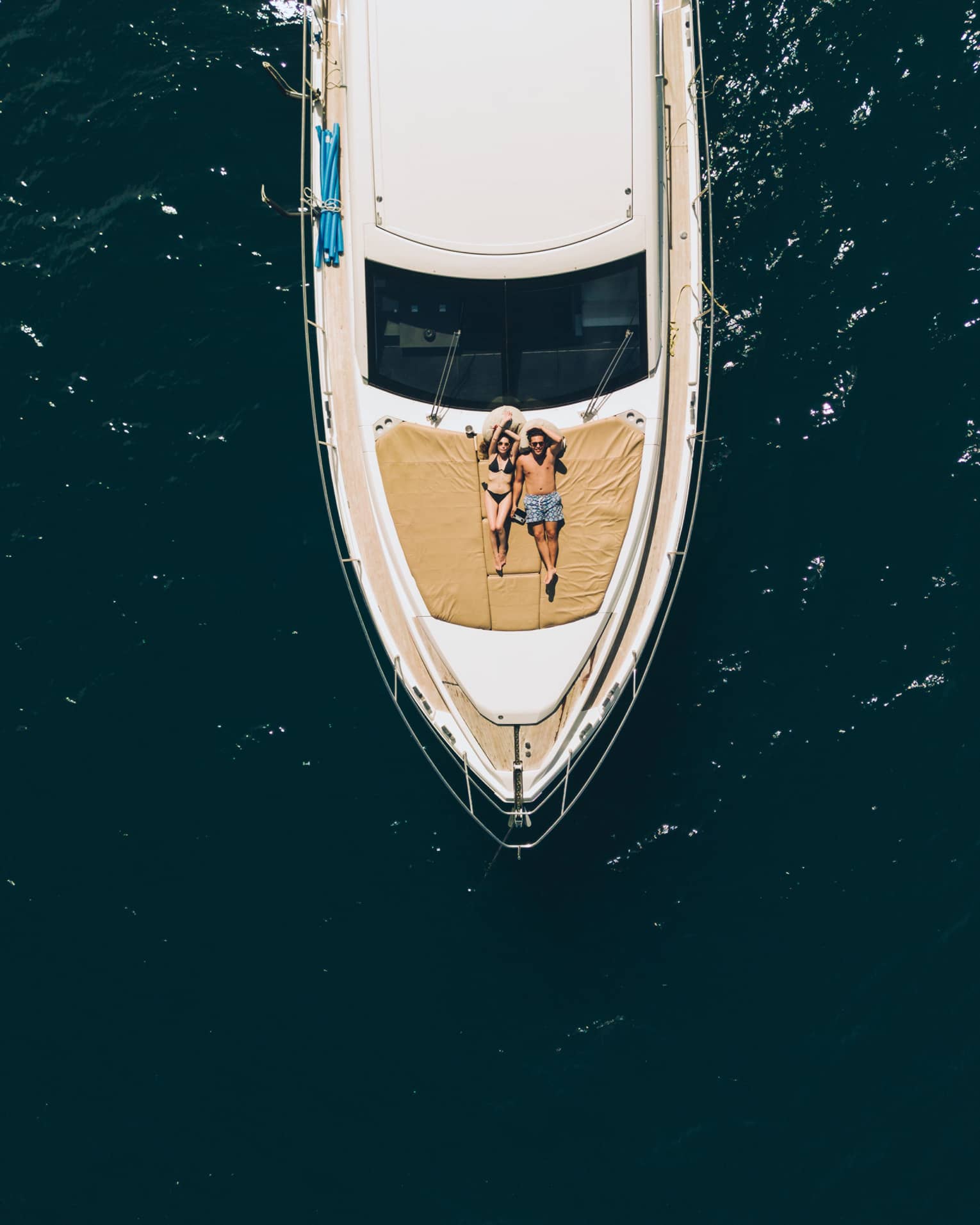 Aerial view of couple relaxing on the front of a large boat