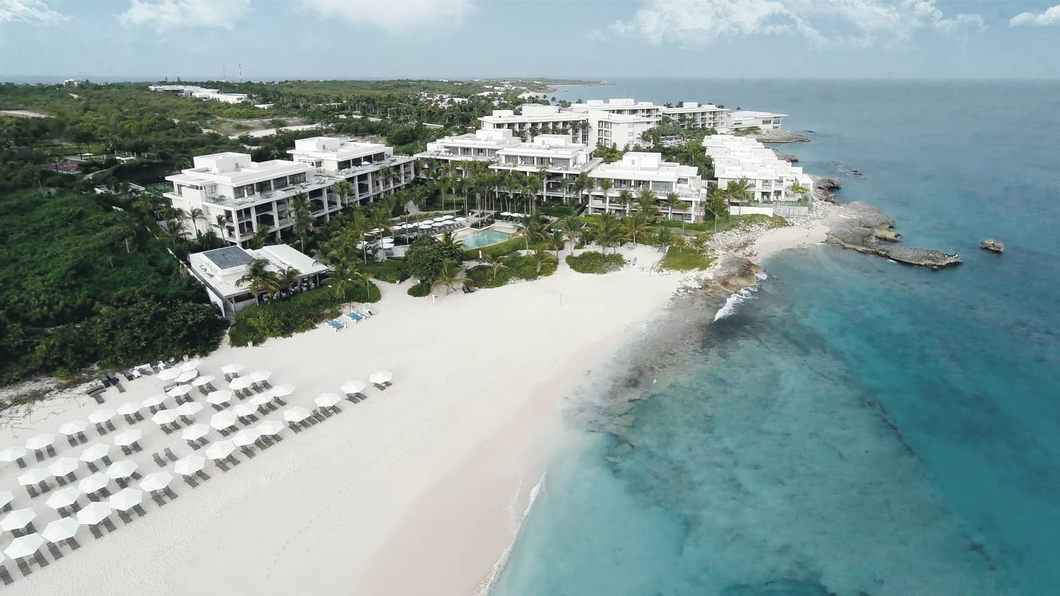 Aerial view of Four Seasons Anguilla resort on white sand beach, turquoise lagoon