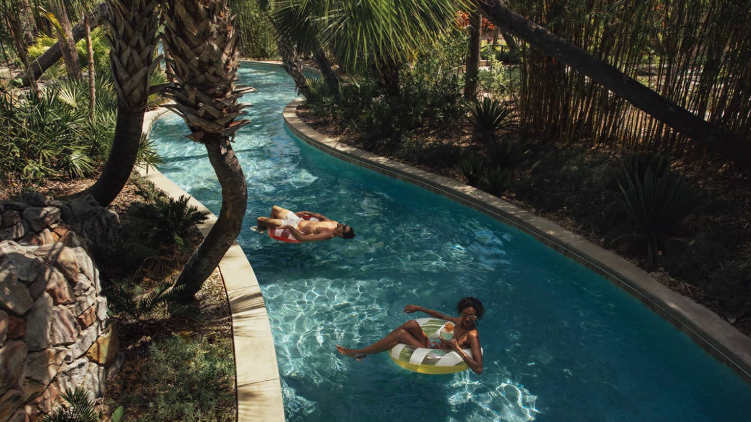 Two guests on floats on the lazy river.