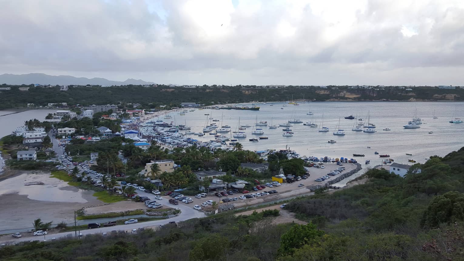 Aerial view of a busy harbour with sails and boats in Anguilla, cloudy skies
