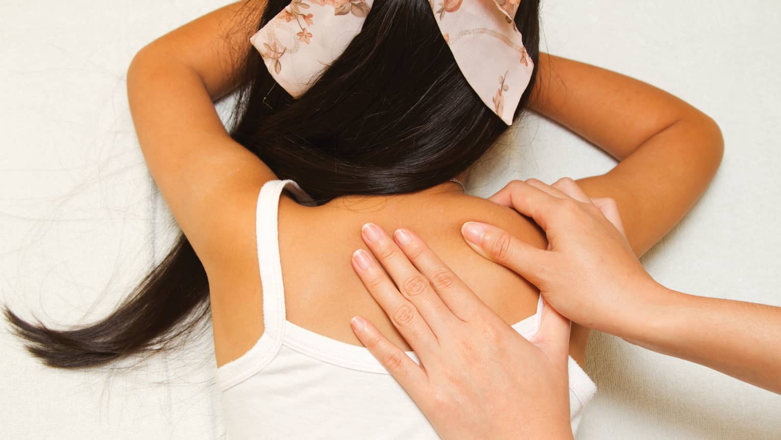 Masseuse hands massage girl's shoulders