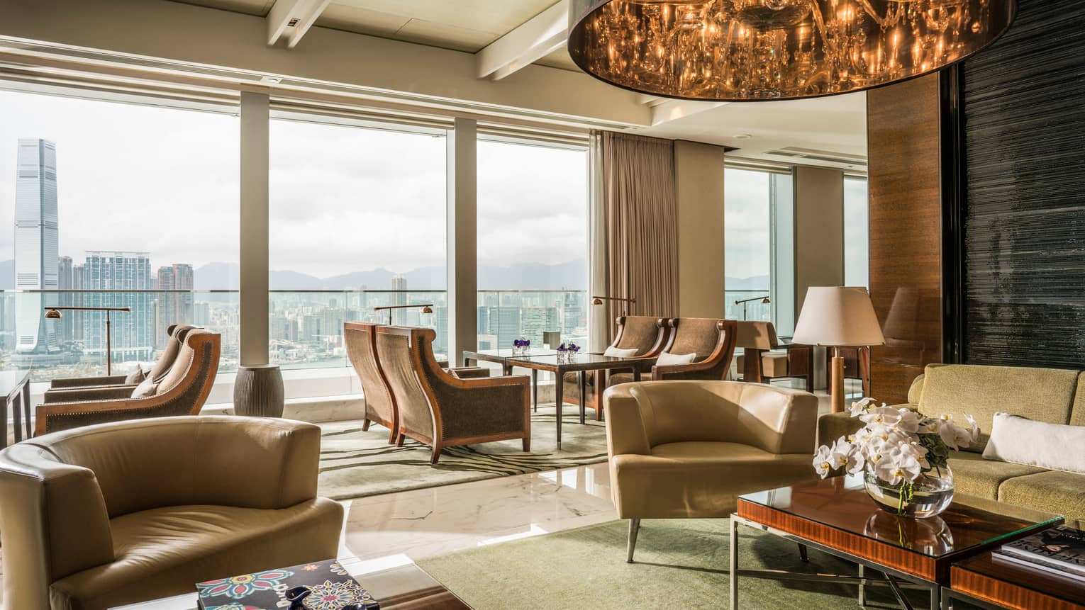 Executive Lounge seating areas with sofas, curved armchairs, bright floor-to-ceiling window, city views