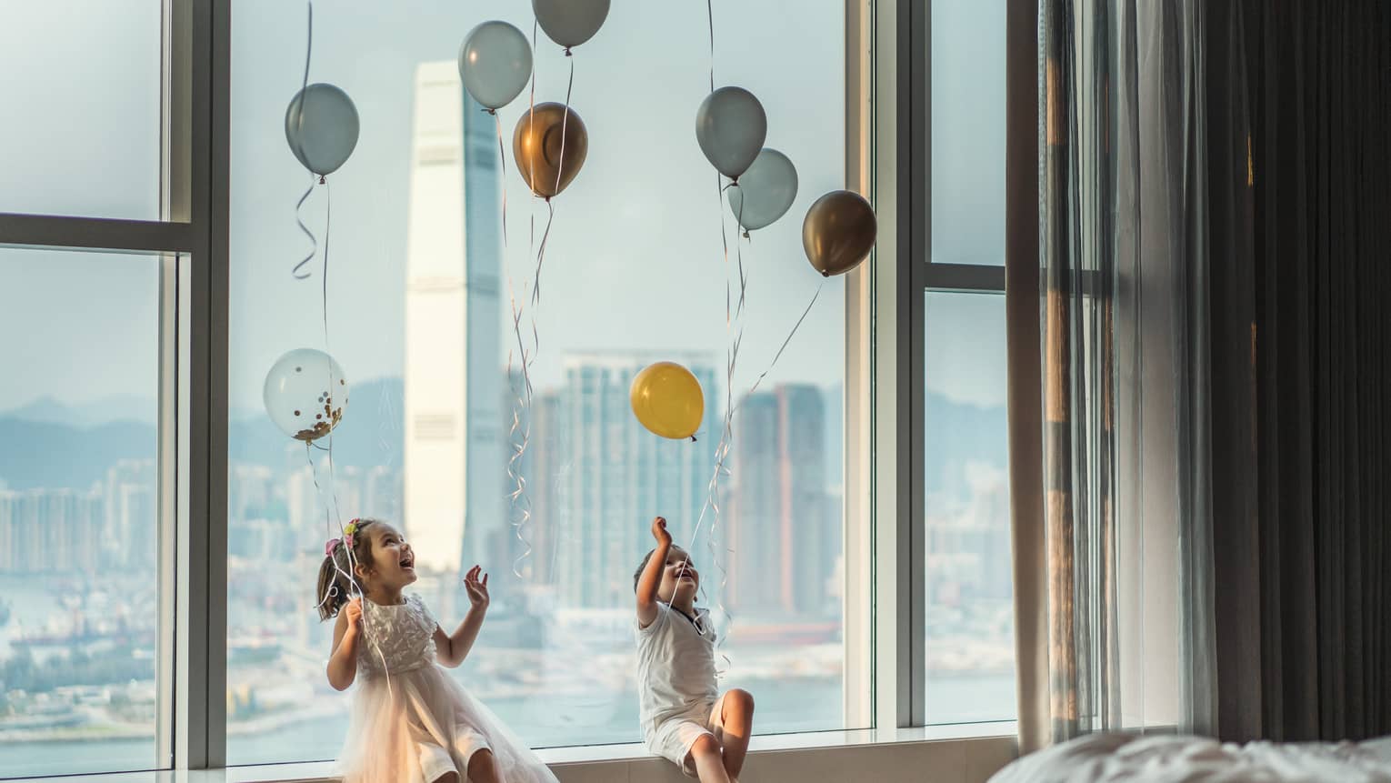 Two young children playing with balloons.
