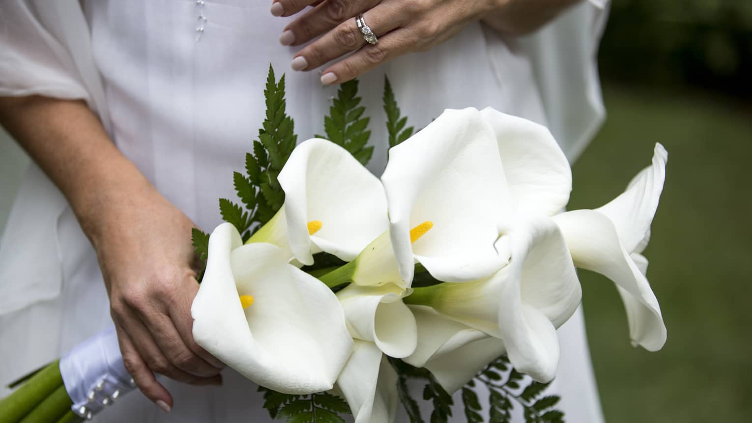 Woman holds bouquet with large white tropical flowers