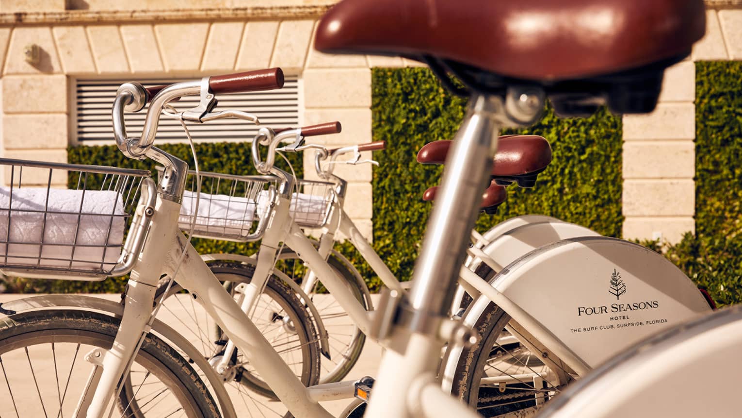 A close up image of white bikes with baskets.