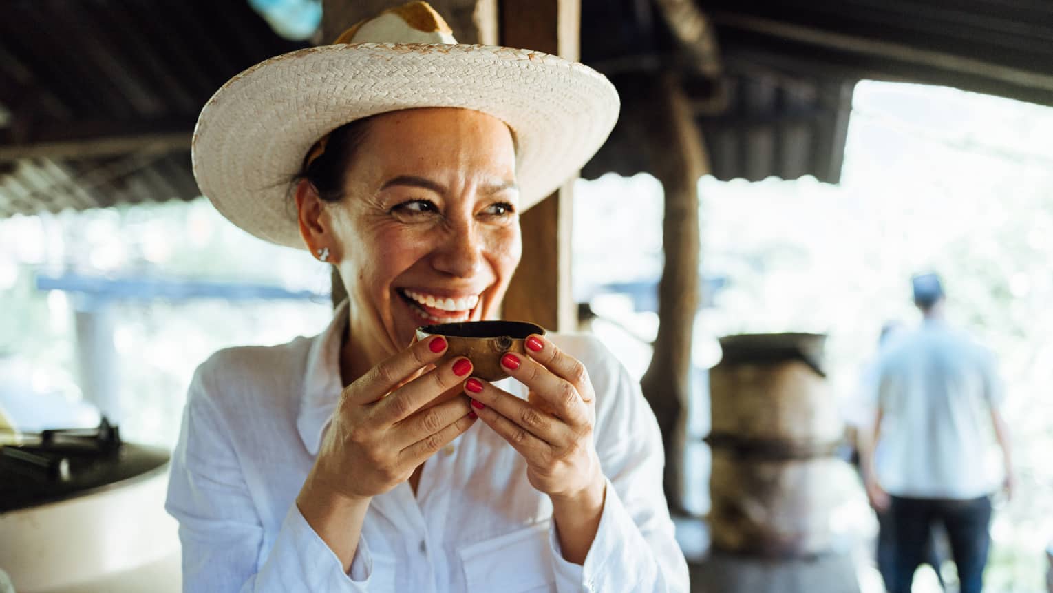 Person wearing a hat and holding a wooden bowl.