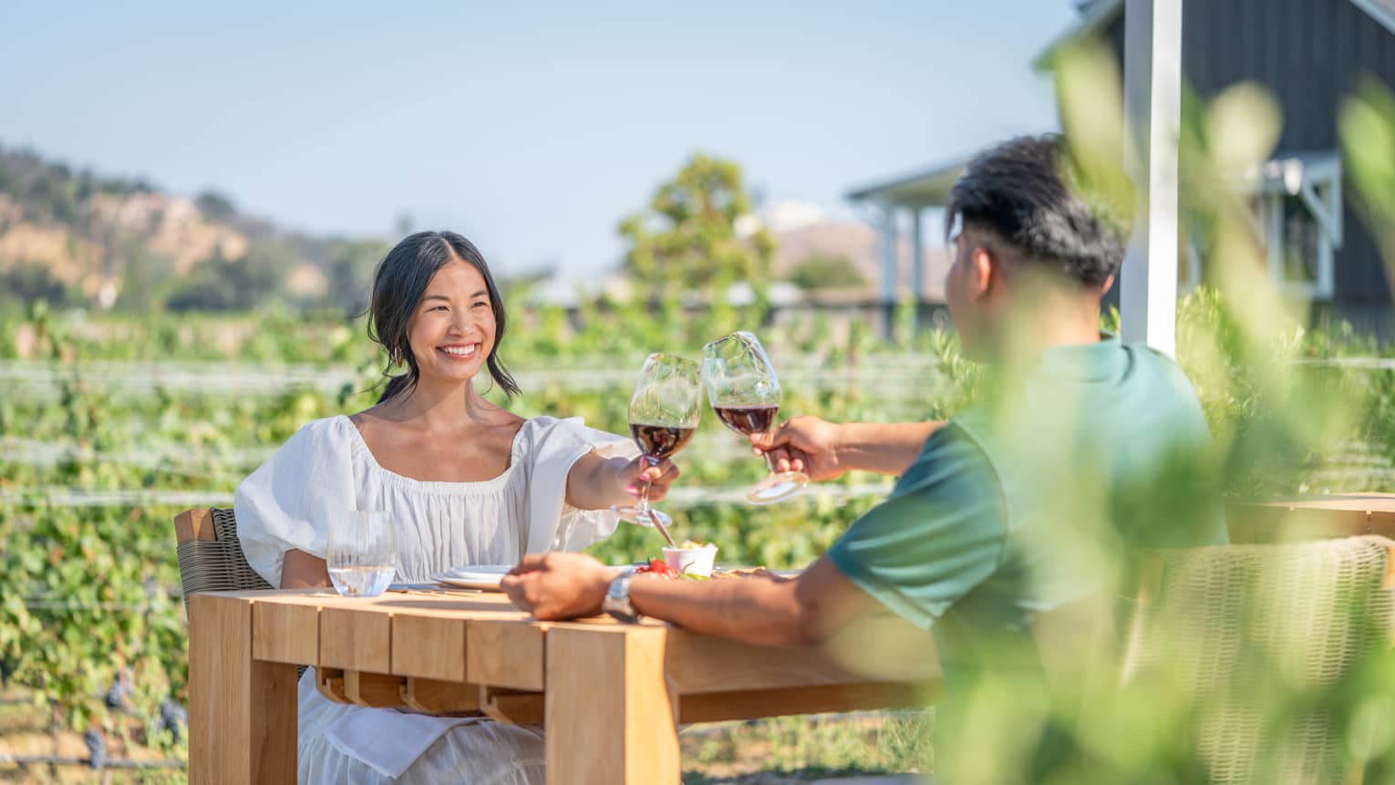 A man and woman enjoying wine outside.