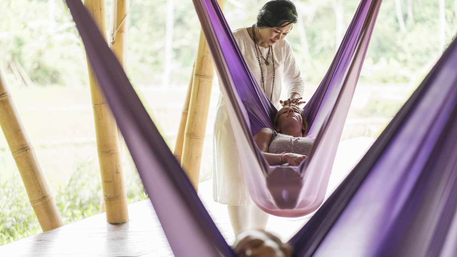 A Four Seasons yoga instructor massages the forehead of a guest during a sacred nap 