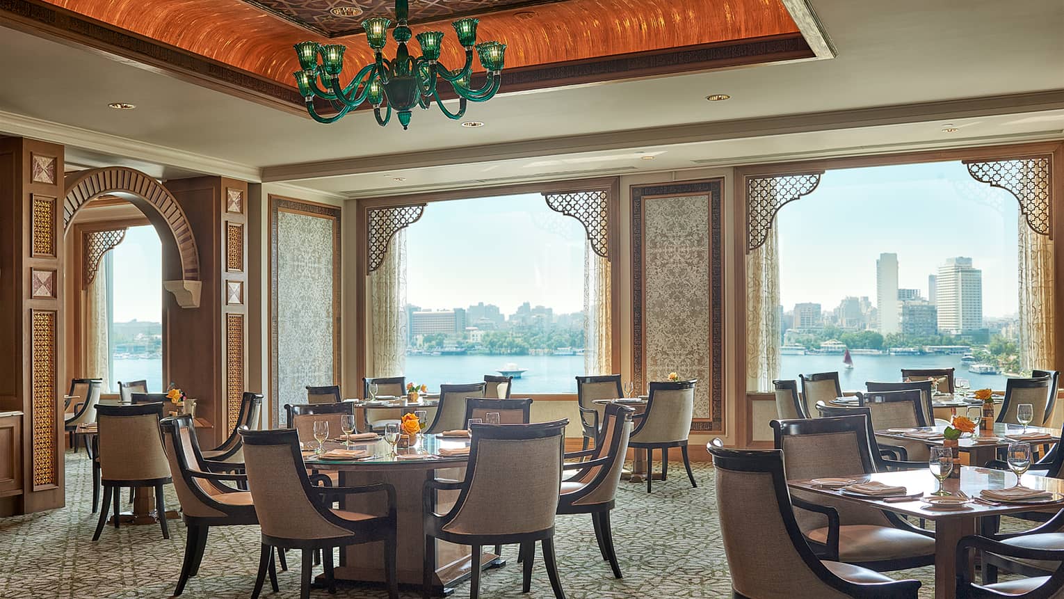 Zitouni Egyptian restaurant dining room tables with high ceilings and windows looking out at Nile river during day