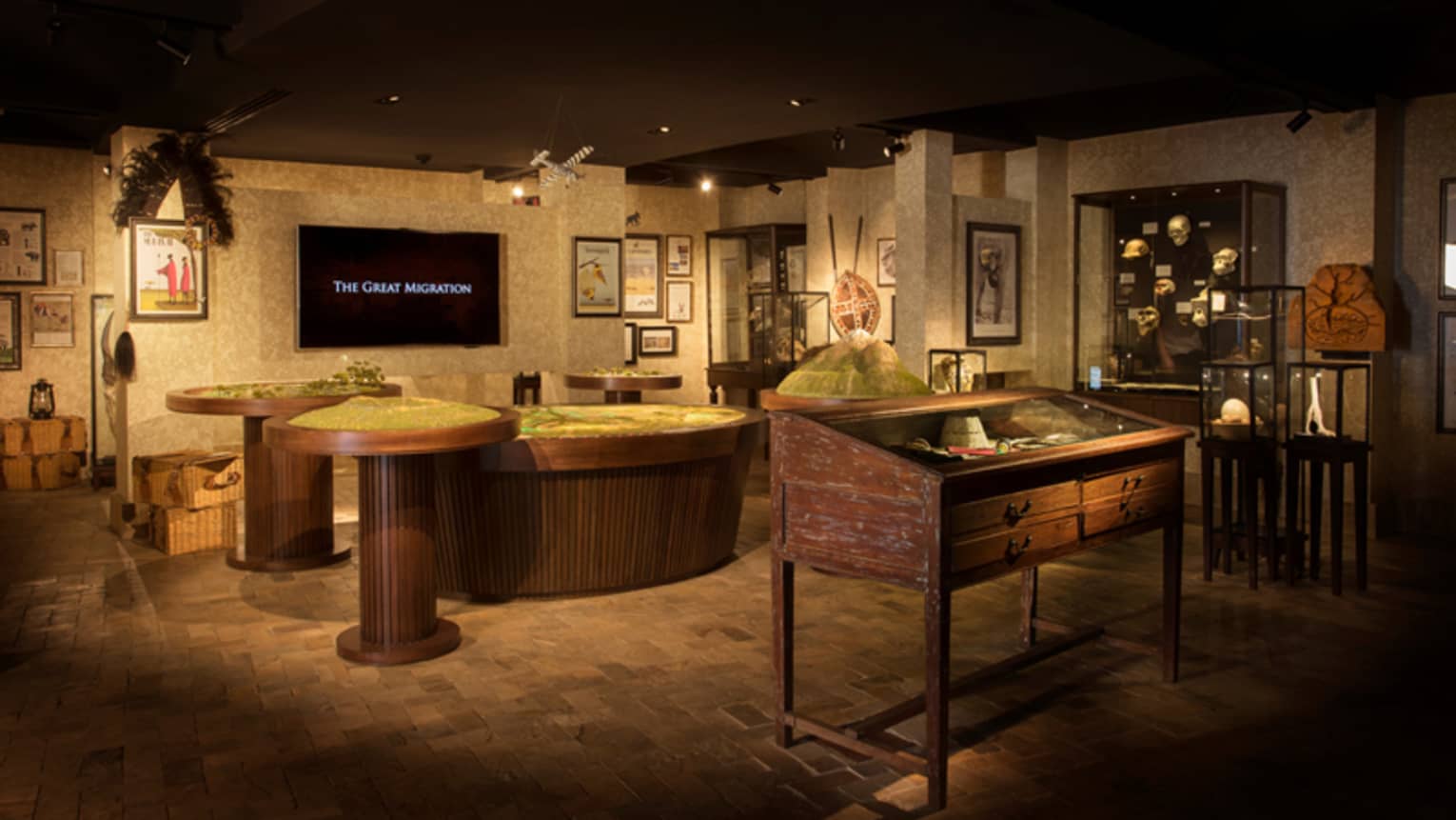 Wide shot of The Great Migration exhibit room with model tables, screen, displays
