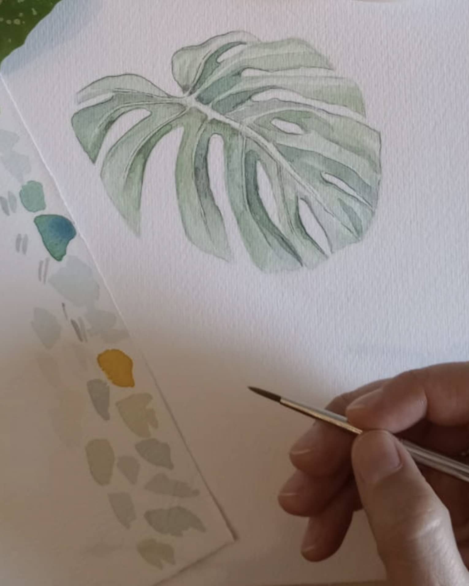 Watercolour painting of a green leaf.