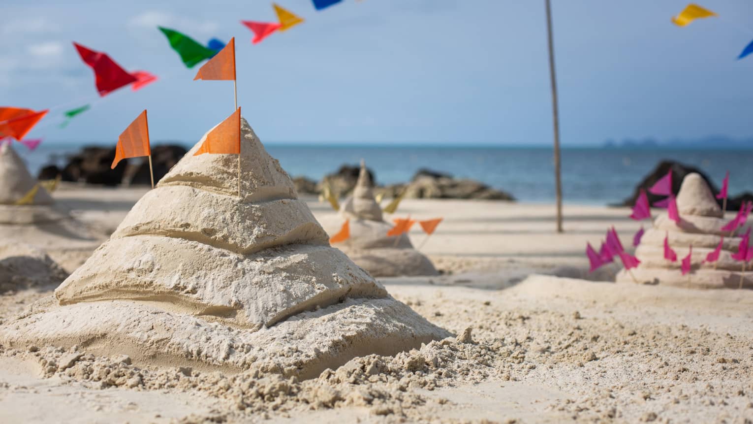 Sand castles adorned with various coloured flags