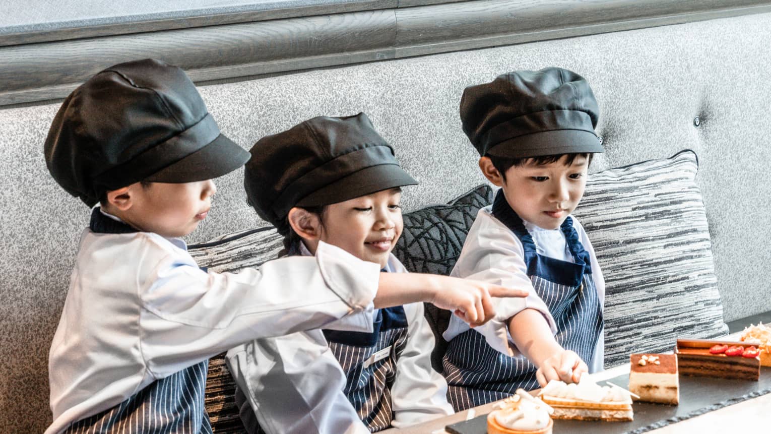 Three kids dressed as chefs participate in Kids Academy at PIGNETO