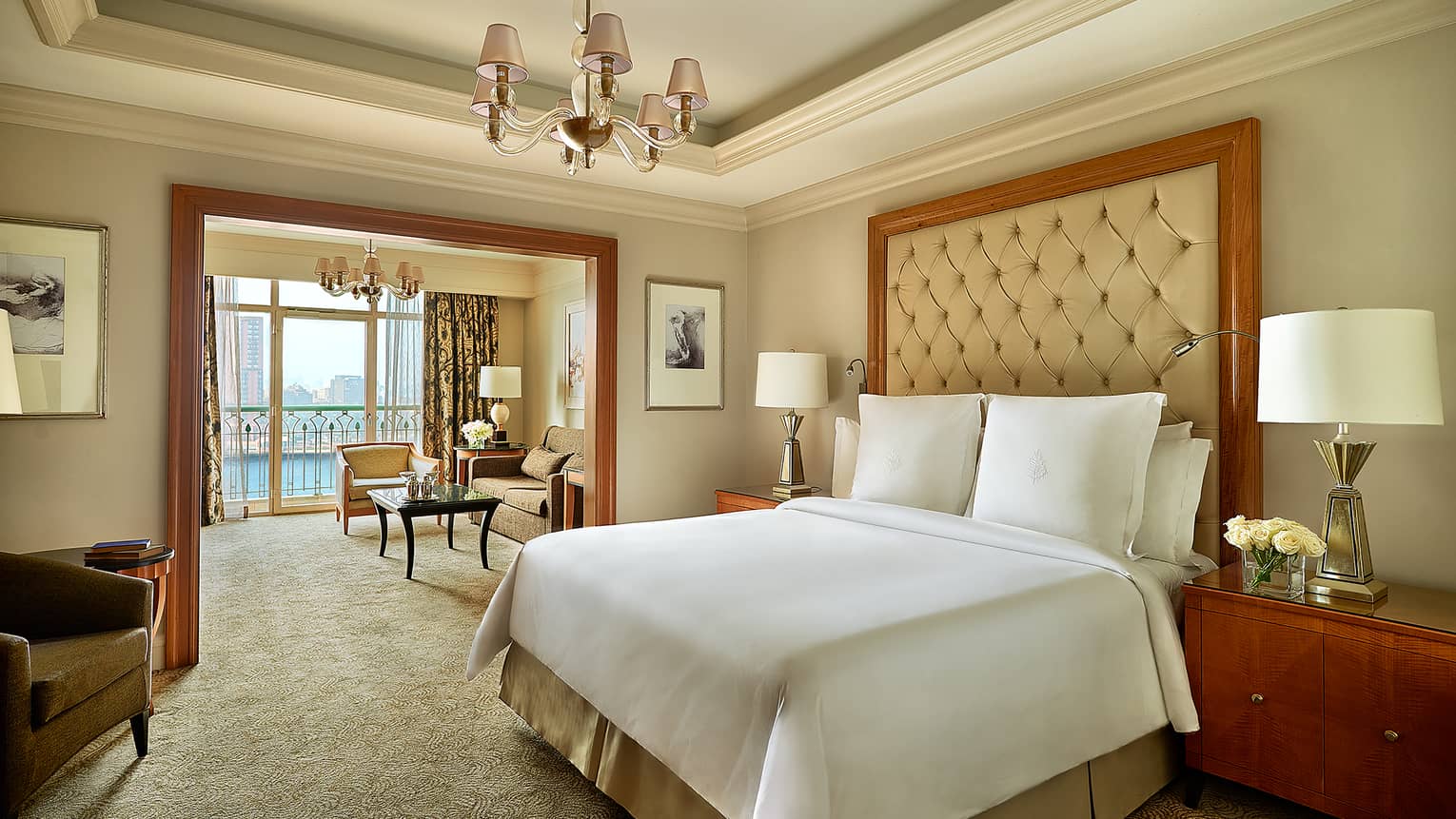 Premier Nile Room bedroom with cream and white tones, bed, high leather headboard, adjoining living room