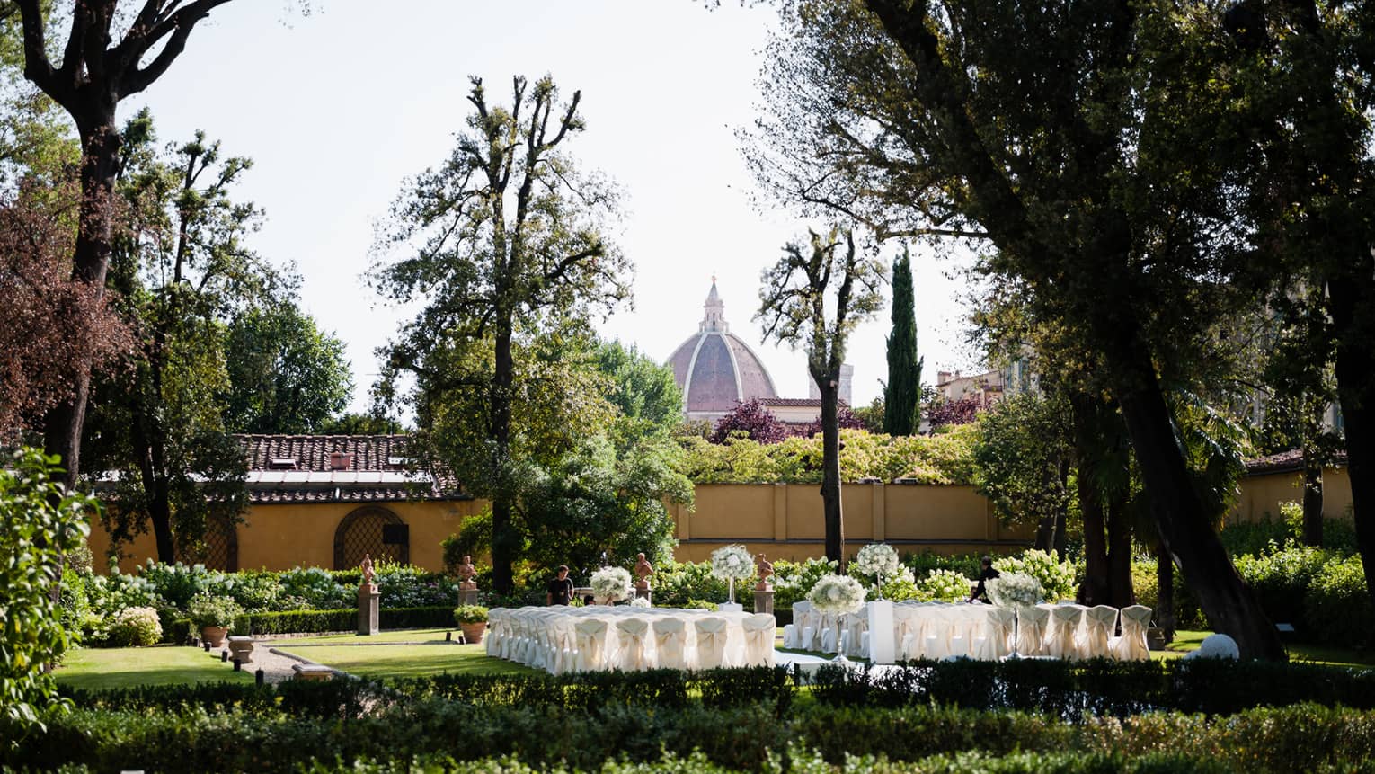 White banquet tables are set in a courtyard in Florence
