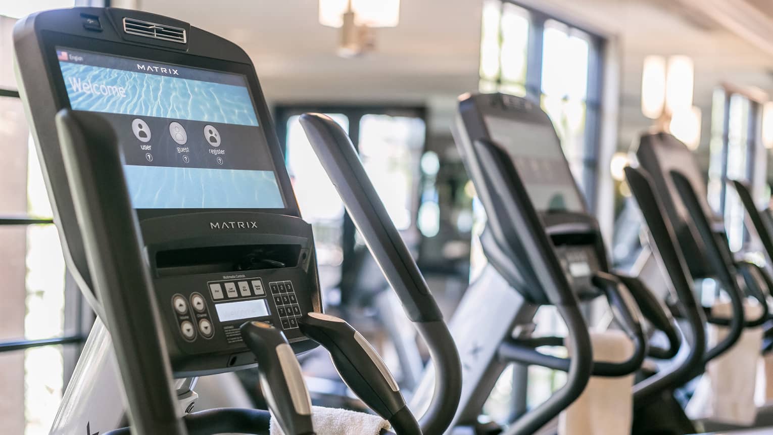 Close-up of Matrix cardio machine screens and handles in a row