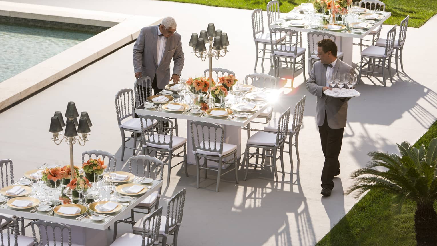 Four Seasons Hotel Ritz Lisbon staff set small banquet tables on outdoor event terrace