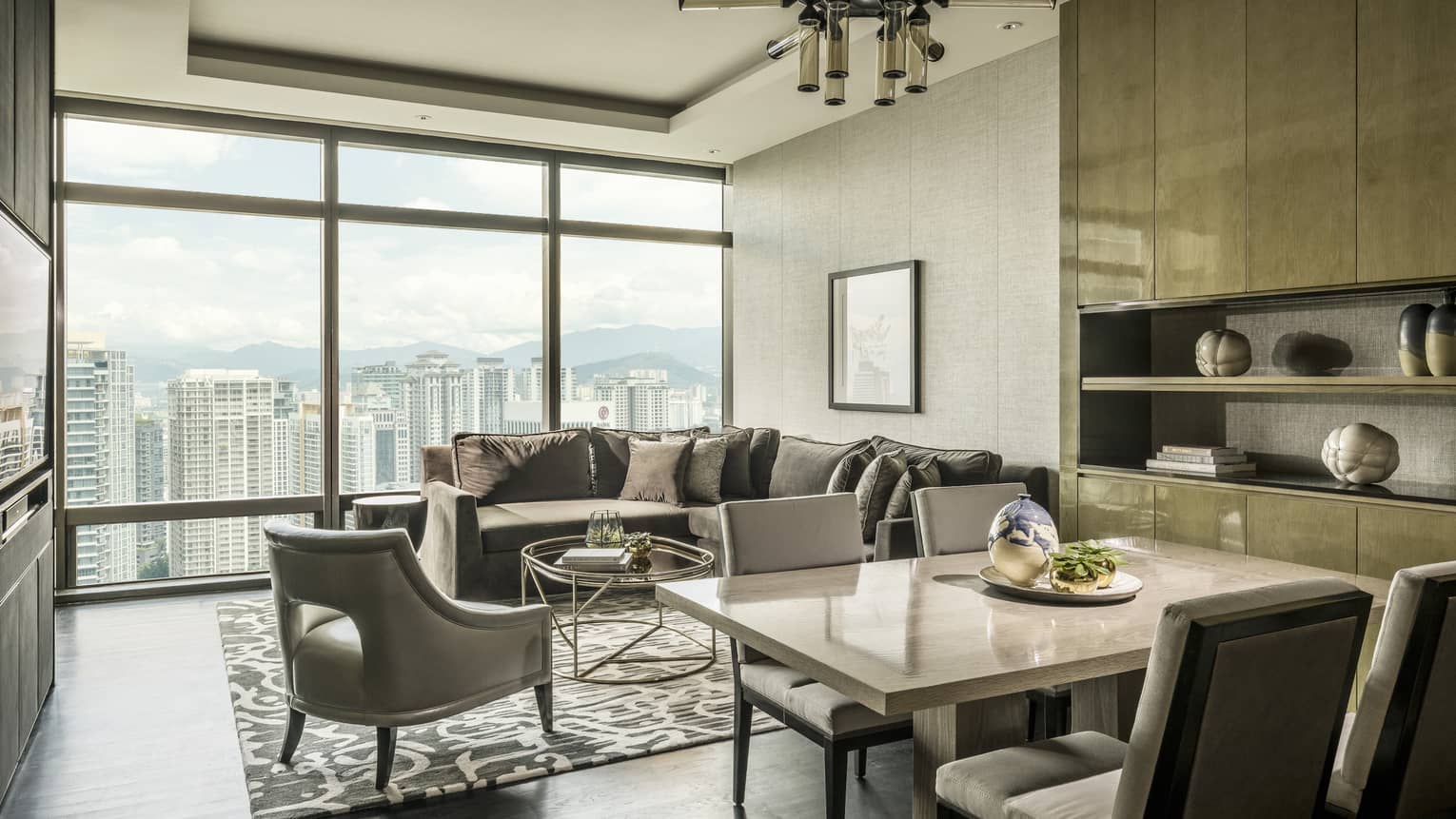 Stylish living area, with dining table and L-shaped sofa, looking out to Kuala Lumpur