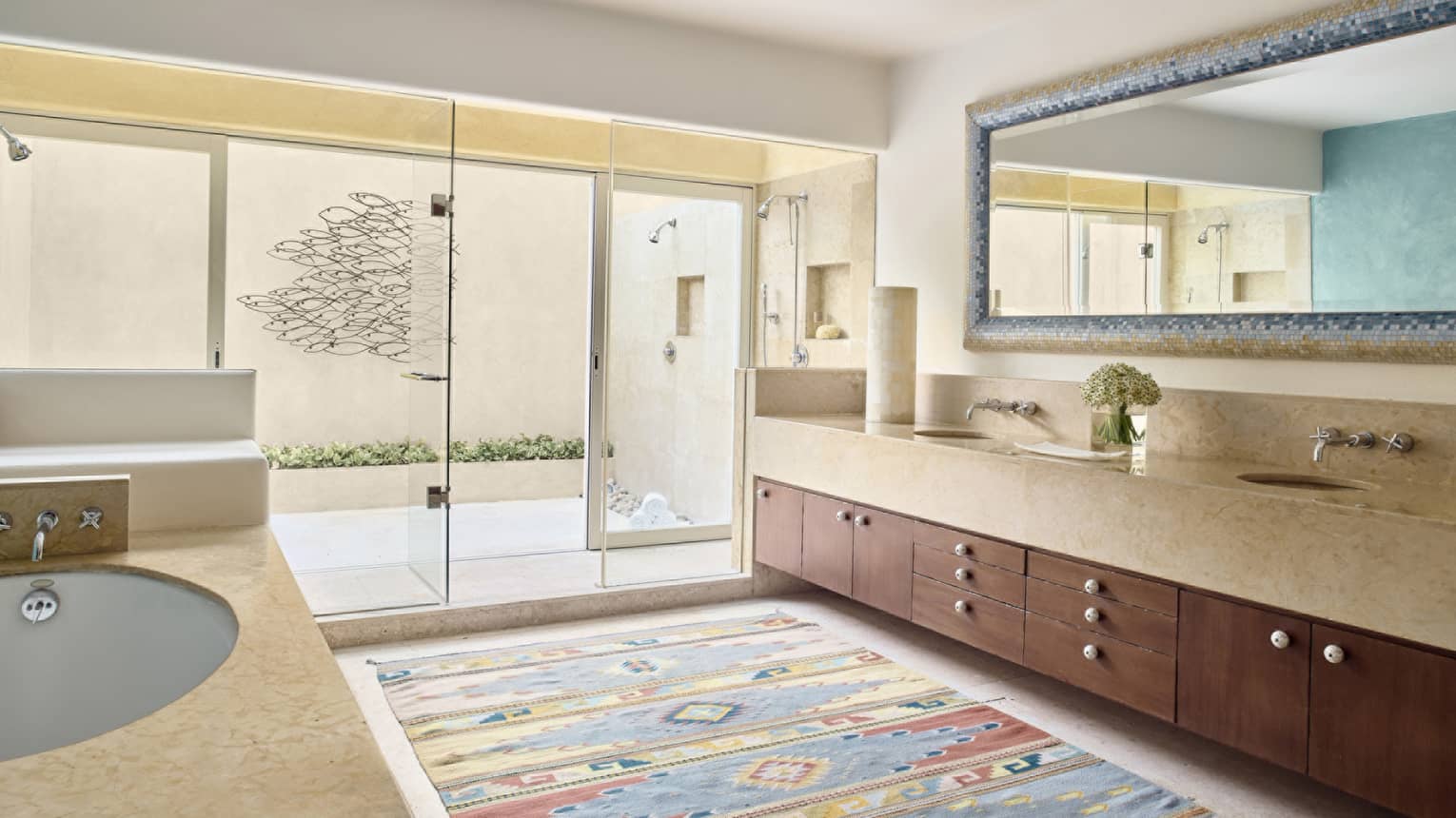 Large bathroom with Mexican motif rug, double vanity, walk-out terrace