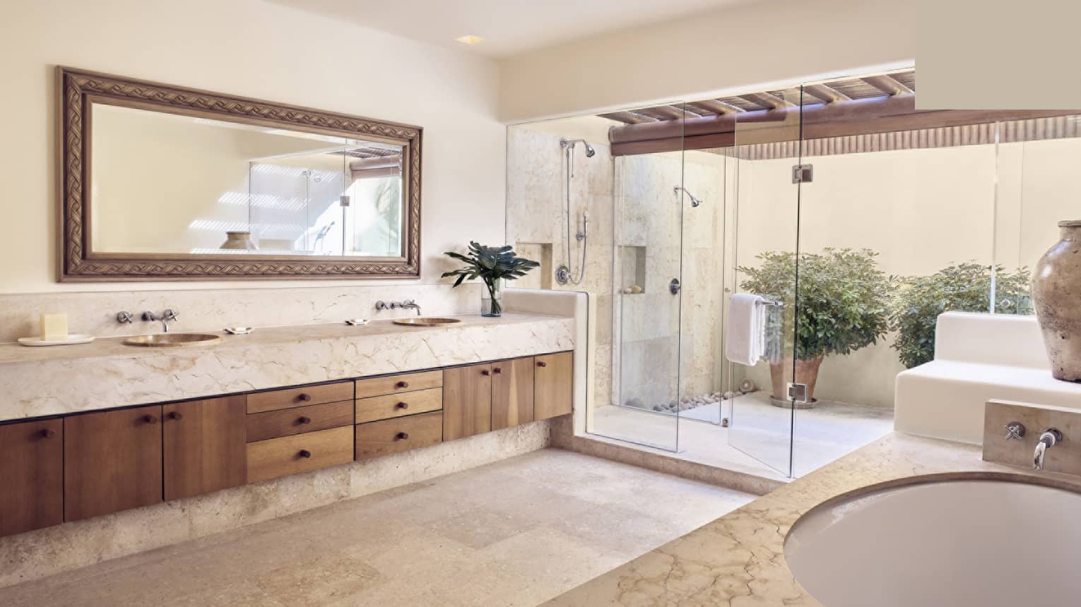 Large bathroom with double vanity, tub, walk-out outdoor shower