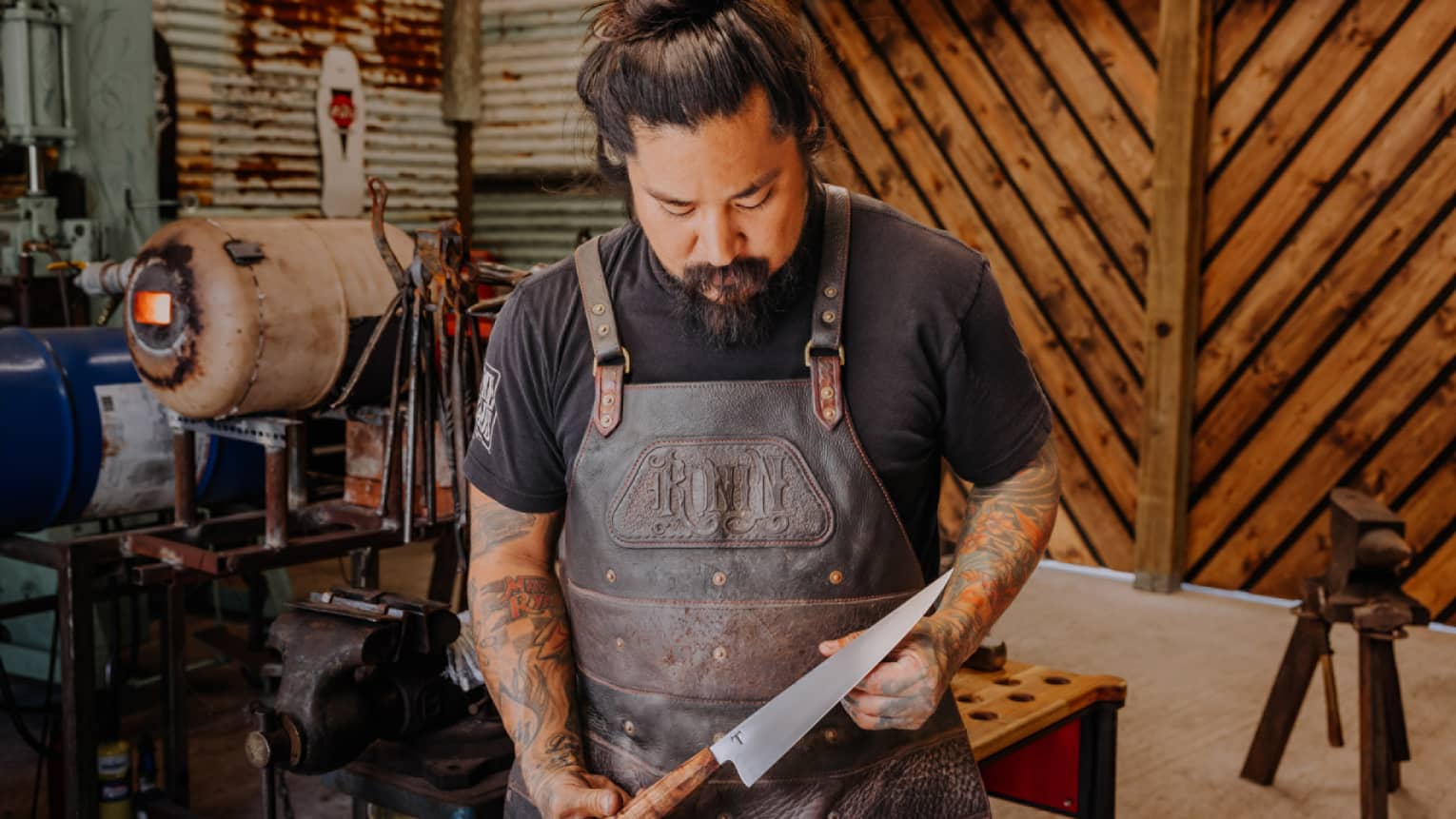 A blacksmith examines a chef's knife in his Hawaii Island shop