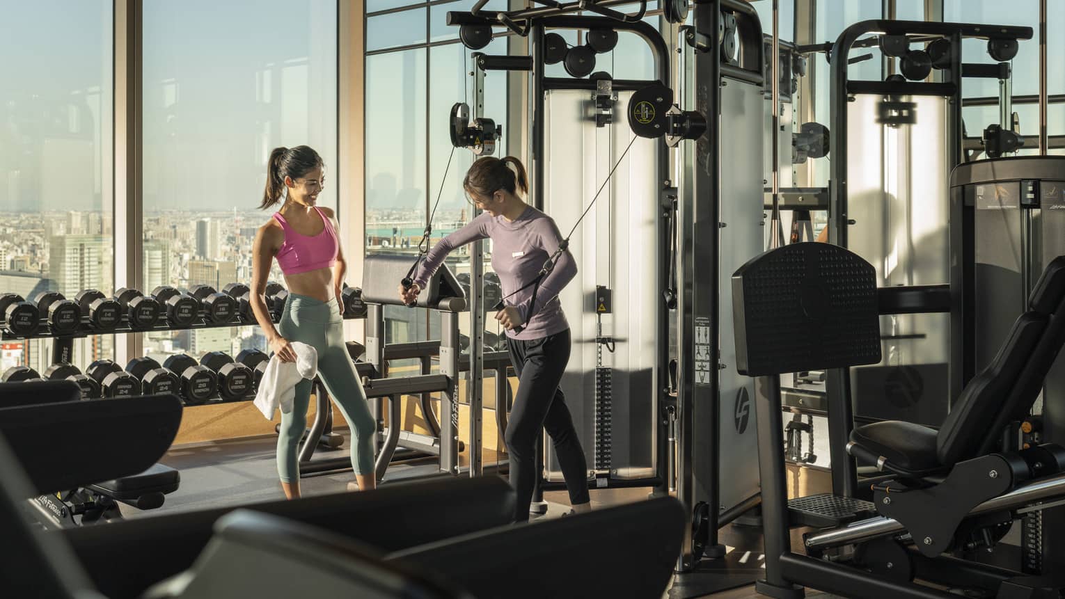 Trainer shows woman how to use exercise machine during a private session
