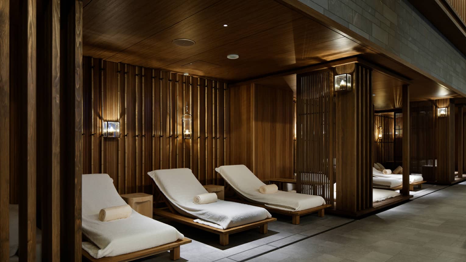 Lounge chairs with white towels under wood walls in spa