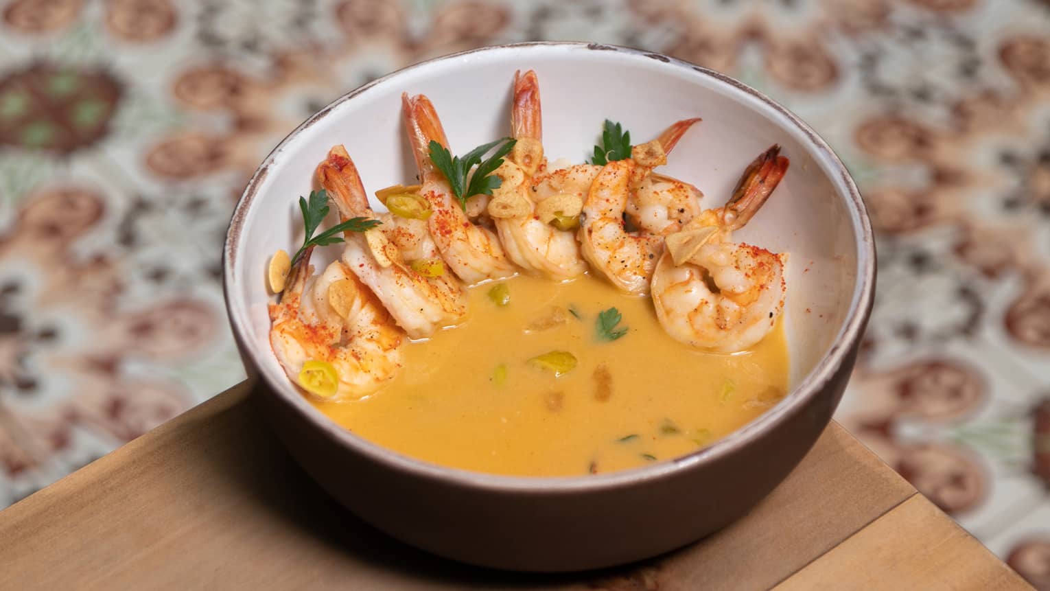 Shrimp in a yellow sauce served in a ceramic bowl.