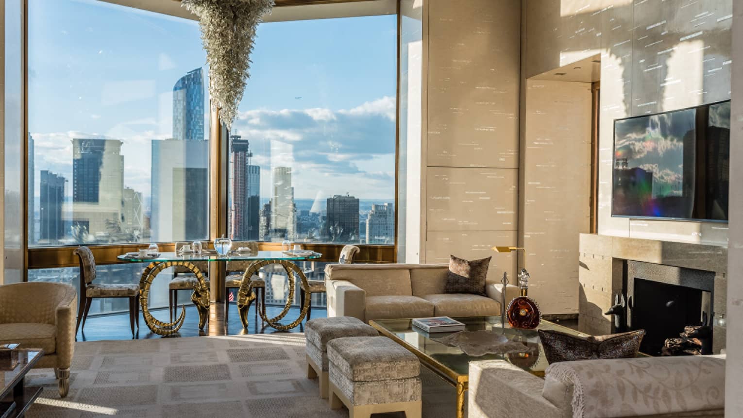 Bright Ty Warner Penthouse with modern gold dining table, chandelier by floor-to-ceiling window