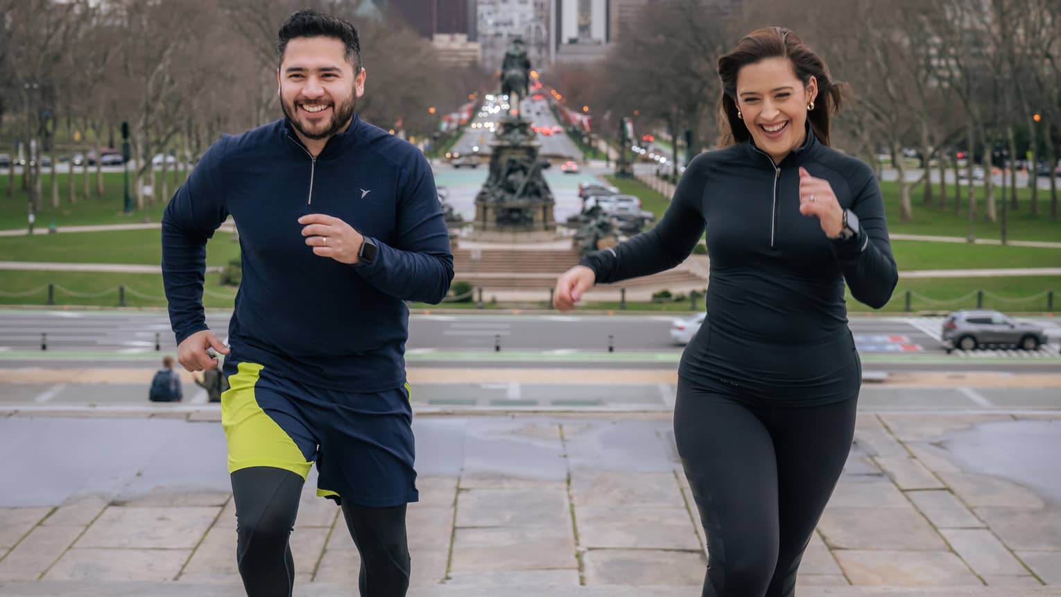 Two guests wearing exercise clothes and running outside.