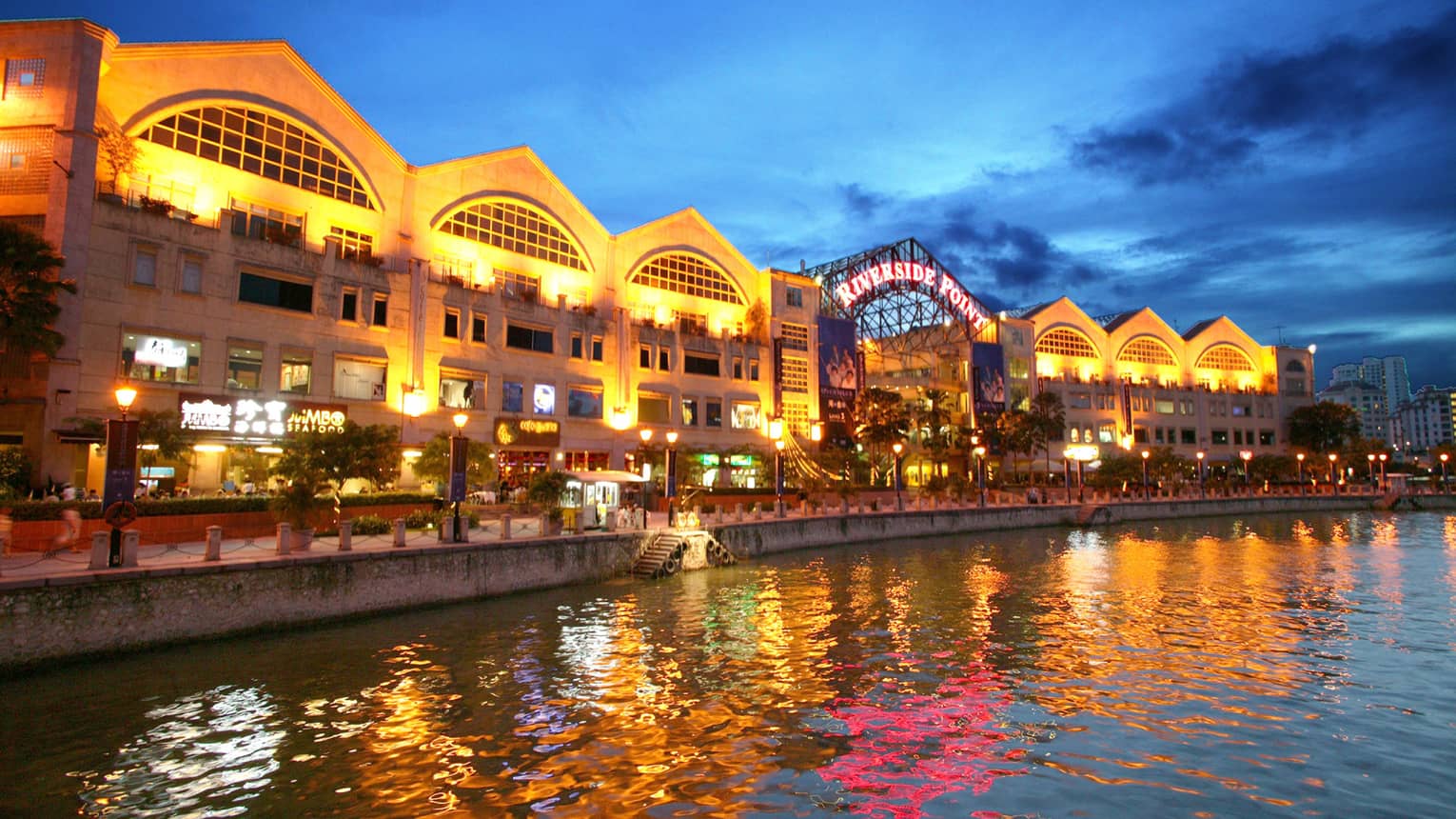 ,A shopping center by the water lit up at night