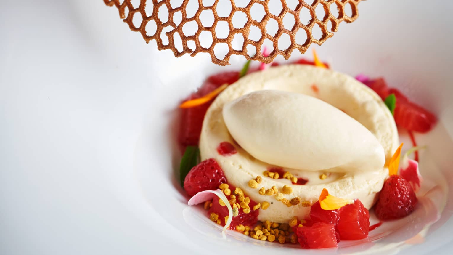 Honey parfait, strawberries and goat milk ice cream in a bowl.