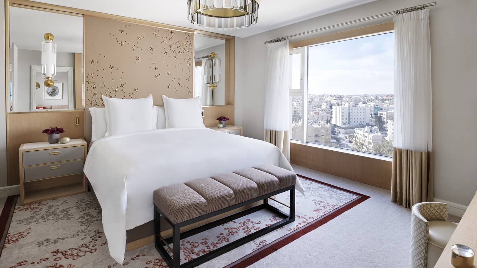 A floral-themed room with a large bed in the centre, and a cityscape view. 