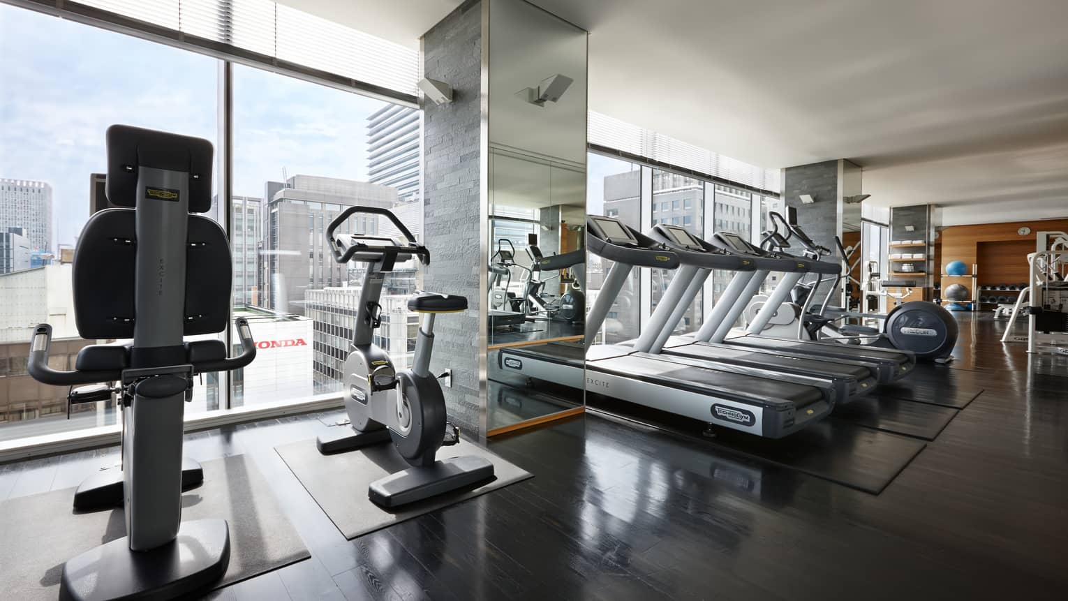 Elliptical machines, treadmills, cardio equipment by sunny window in Fitness Centre