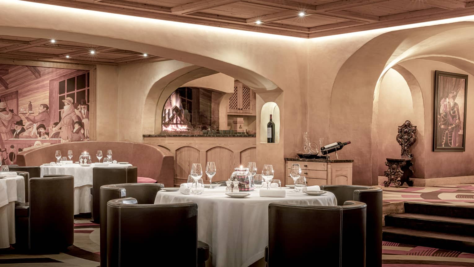 Restaurant with round set tables, rounded chairs, tan walls, mood lighting archways