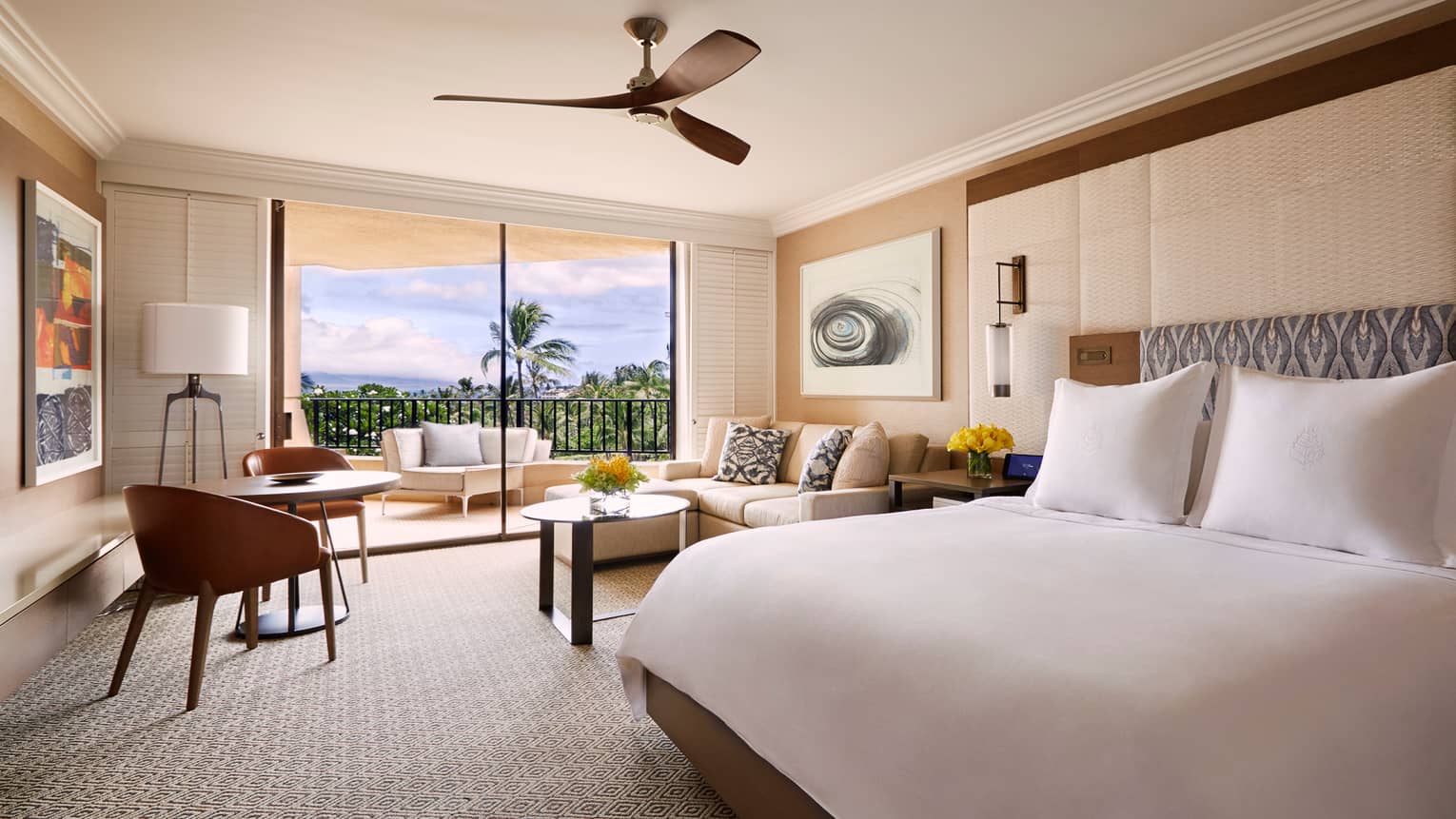 Ocean-View Prime room with king-sized bed and two-seat dining table, white sofa beside patio door